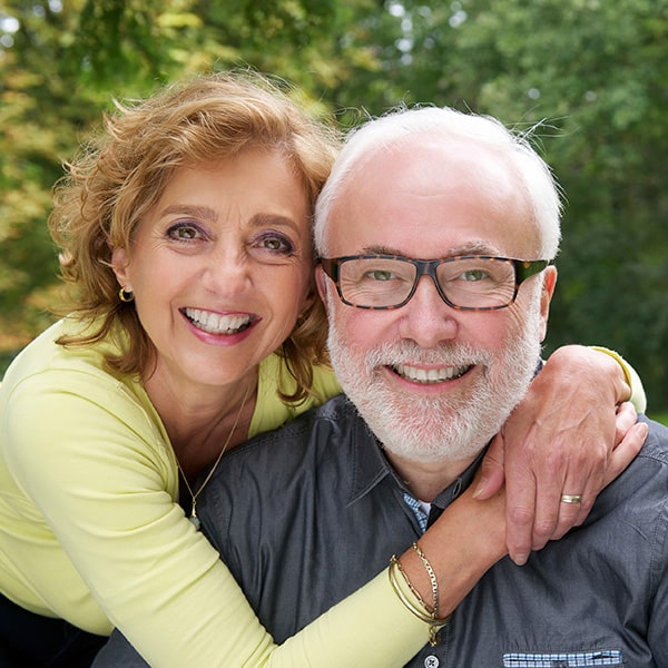 Couple smiling in a garden while hugging