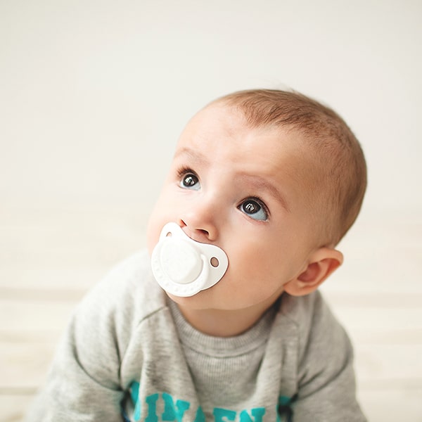 A baby with a pacifier crawling